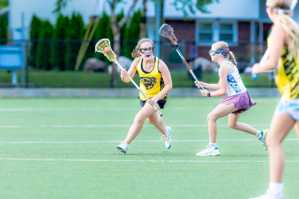 A Gale player cradling the ball as a Frost defender closes in